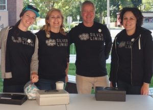 Volunteers pose for a photo while providing wrist bands at the 2017 NE Food Truck Rally