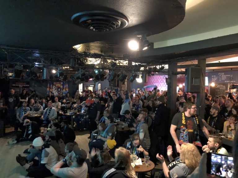 Many members of the Dark Clouds during the first watch party of the season, gathered around a screen at the Black Hart of Saint Paul.