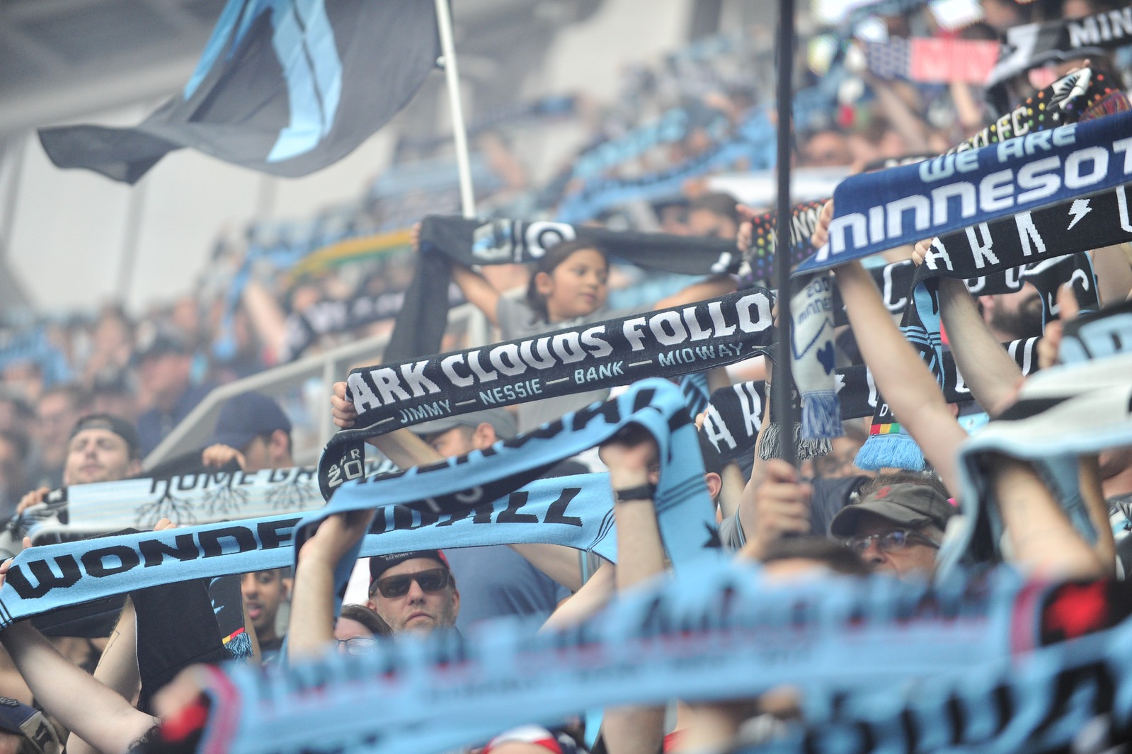 Photo of Wonderwall during game with people holding up Dark Clouds and Wonderwall scarves and flags