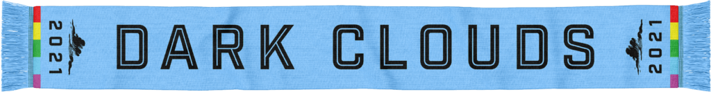One side of the 2021 scarf. Powder blue in color (including the scarf fringe), the scarf includes a rainbow band to symbolize inclusivity at each end. Also at each end, the Dark Clouds logo and 2021 appear. DARK CLOUDS is printed in black block letters across the length of the scarf.